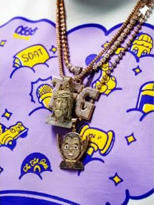 Cadenas doradas con dijes sobre una camiseta estampada de O66Y